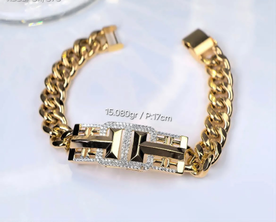 Gelang rantai emas tebal model sisik naga dengan plat geometris bertabur permata di tengahnya.